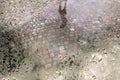 Street with cobble stones and puddle after rain seen through wet window pane Royalty Free Stock Photo