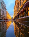 Reflection in a puddle of a city street decorated with festoons