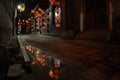 Reflection in puddle of Red lanterns and bokeh at night in a street in Pingyao. The ancient city of Pingyao is a famous tourism de