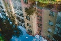 Reflection in the puddle of water. Apartment house with balconies. Blue sky with clouds in the puddle Royalty Free Stock Photo