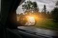 The reflection of road in the side view mirror with raindrops. Travel concept. Bad weather and grey sky Royalty Free Stock Photo