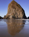 Reflection of a rock islet on the beach during low tide