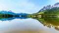 Reflection of the Rocky Mountains range on the smooth water surface of Yellowhead Lake in Robson Provincial Park Royalty Free Stock Photo