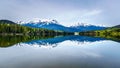 Reflection of the Rocky Mountains range on the smooth water surface of Yellowhead Lake in Robson Provincial Park Royalty Free Stock Photo