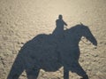 Reflection on the sand a man riding a horse silhouette rider