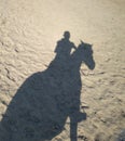 Reflection on the sand a man riding a horse silhouette rider