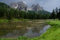 Reflection of Sassolungo and Langkofel mountain group and blue sky in lake, Picturesque. Alpe di Siusi or Seiser Alm with