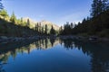 Reflection of the shore of the lake in the watery surface. Early sunny morning. The large lower Shavlinsky lake. Altai Mountains Royalty Free Stock Photo