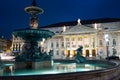 Reflection of sign of National Theatre at illuminated fountain at Rossio Square in Lisbon