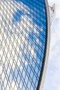 Reflection of sky and clouds in glass spiral, wave with bend facade windows of financial skyscrapers. Royalty Free Stock Photo