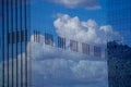 Reflection of the sky and clouds in the glass wall of a high-rise building. Glass wall of a skyscraper. Mirrored wall of Royalty Free Stock Photo