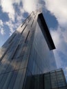 Reflection of sky and clouds on tall modern