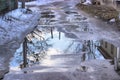 Reflection of sky sun and clouds in puddles