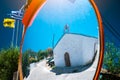 Reflection of small greek chapel in the traffic safety mirror. Royalty Free Stock Photo