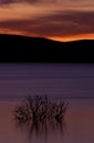 Reflection on smooth lake at sunset, dramatic sky