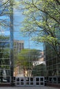 Reflection of the street buildings and trees in the windows of a modern high-rise building with a glass facade. Royalty Free Stock Photo