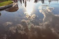 Reflection of the sun and blue sky with clouds in a puddle. Royalty Free Stock Photo