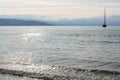 Reflection of the sun in the sea water and silhouette of sailing ship on the horizon. Royalty Free Stock Photo