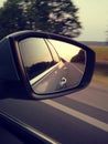 Reflection of sunny road at the car side mirrow. Rear view mirror reflection on sun down Royalty Free Stock Photo