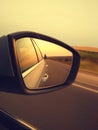 Reflection of sunny road at the car side mirrow. Rear view mirror reflection on sun down Royalty Free Stock Photo