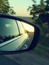 Reflection of sunny road at the car side mirrow. Rear view mirror reflection on sun down Royalty Free Stock Photo