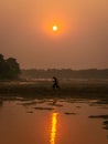 A young man enjoying the reflection of the red sun on the river Royalty Free Stock Photo