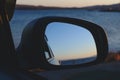 Reflection of the sunset in the sea in a car side view mirror. Royalty Free Stock Photo