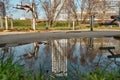 Reflection of tall building at puddle of water Royalty Free Stock Photo