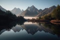 reflection of towering mountain range and lake in misty morning light Royalty Free Stock Photo