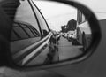 Reflection of a traffic jam in a sideview mirror. old black and white photography filter applied Royalty Free Stock Photo