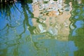 Reflection of a tree and a building distorted by the movement of water Royalty Free Stock Photo