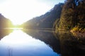 reflection of trees in clear water at sunrise on Ranu kumbolo lake