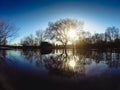 Reflection of trees in spring water river at sunset time, silhouette of car and people at nature background Royalty Free Stock Photo