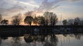 Reflection of trees in water in sunset at small harbor on Lake Constance in Hard near Bregenz in Austria Royalty Free Stock Photo