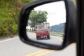 Reflection of a truck in left side rear view mirror at a rural road in Colombia