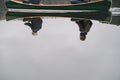 Reflection of two men in a boat. Canoe paddling lifestyle image: people are reflected in clear water