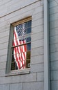 Reflection of the US flag seen within a large window as seen at a famous US university.