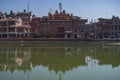Reflection in a water pond of a stone wall and a few old residential buildings on December 23, 2019 in Bhaktapur, Kathmandu, Nepal