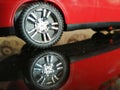 Reflection of a wheel of a toy car on the glass. Royalty Free Stock Photo