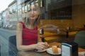 Reflection in the window, a young woman sitting in a cafe Royalty Free Stock Photo