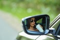 Reflection of woman in rear view mirror of a car Royalty Free Stock Photo