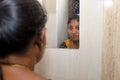 Reflection of a woman in the mirror reflection in the bathroom Royalty Free Stock Photo