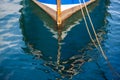 Reflection of a wooden fishing boat in water