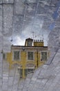 Reflection of a yellow old building in the rainwater