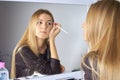 Reflection of young beautiful woman applying her make-up Royalty Free Stock Photo