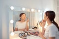 Reflection of young beautiful woman applying her make-up, looking in a mirror Royalty Free Stock Photo