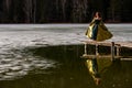 Reflection of a young woman with medieval long dress on the frozen lake in the winter season , forest in the background Royalty Free Stock Photo