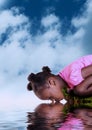 Reflections of an African girl drinking from a river Royalty Free Stock Photo