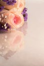 Pink roses and small lavender and white flowers on a reflective background with copy space Royalty Free Stock Photo