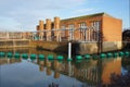 Old red brick industrial building with reflections in river